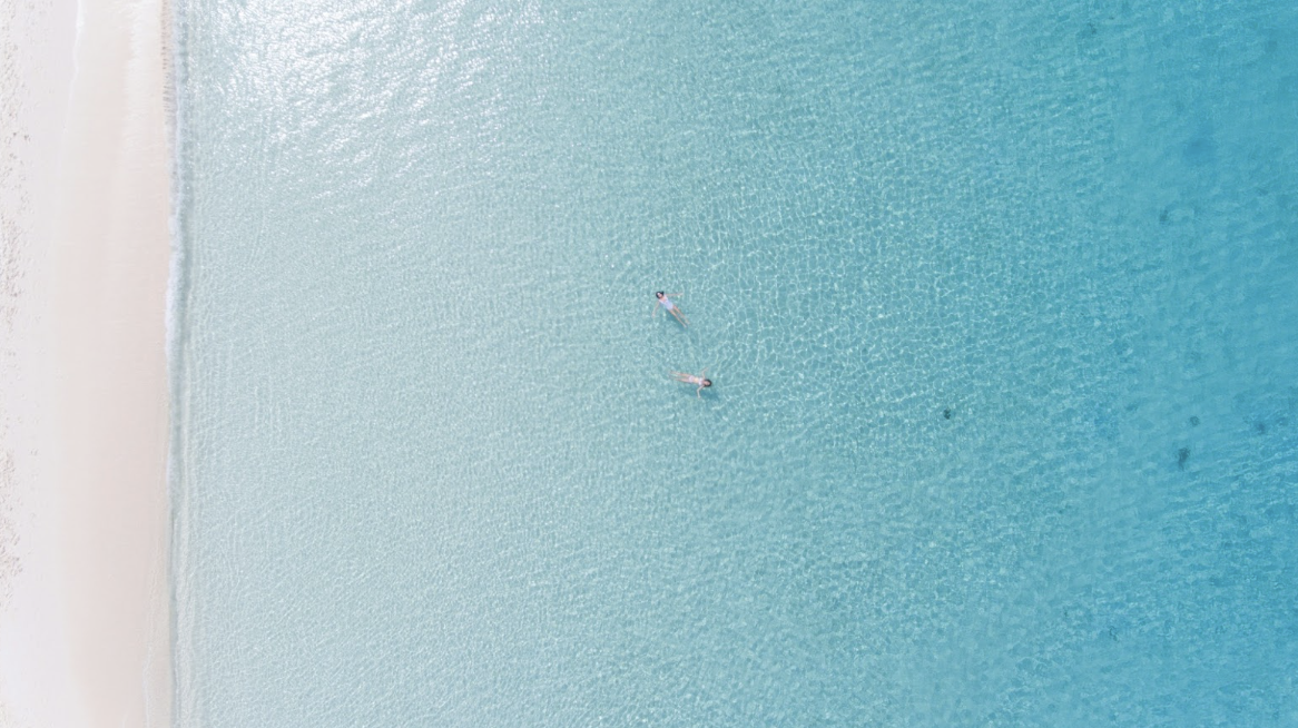 Stunning seven mile beach, Grand Cayman, people float in water