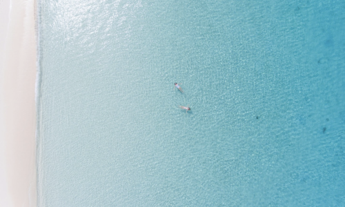 Stunning seven mile beach, Grand Cayman, people float in water