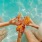 people sit in pool with drinks