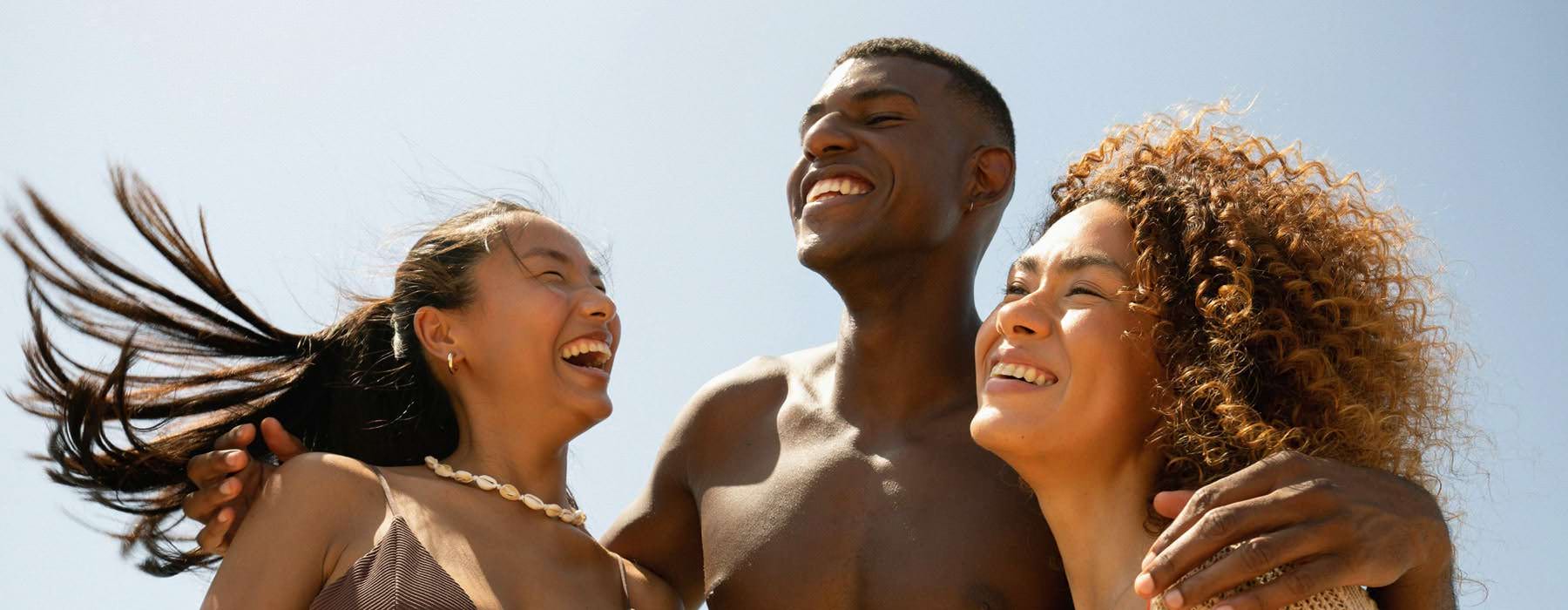 people smiling outside against a blue sky